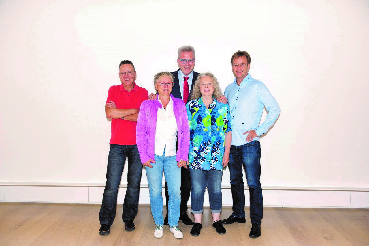 Fünf Personen stehen vor weißer Wand, Gruppe des Landesverbands BDK Berlin, lässige und formelle Kleidung