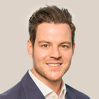 Dr. Moritz Försch trägt einen dunkelblauen Anzug und ein weißes Hemd vor hellem Hintergrund