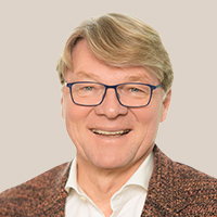 Dr. Thomas Miersch trägt ein weißes Hemd und ein braunes Sakko mit Muster vor hellem Hintergrund